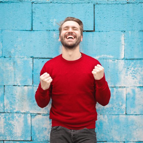 man smiling with clenched fists in celebration